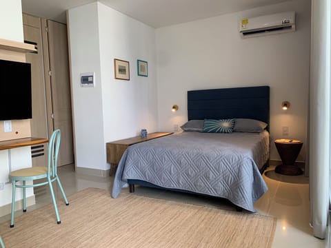 Well-designed studio with a comfortable bed, workspace, TV, and air conditioning