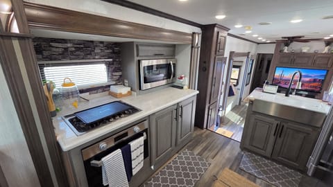Gourmet kitchen setup with stove, oven, microwave, and deep sink