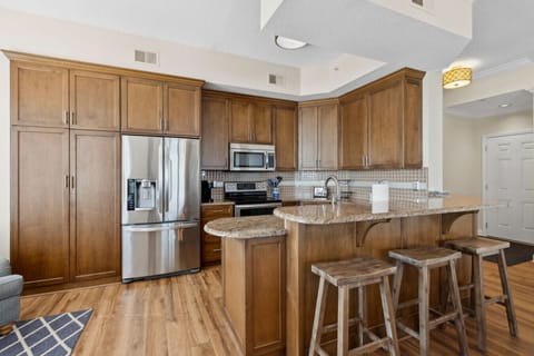 Fully equipped kitchen with warm cabinetry, granite counters, and stainless appliances.