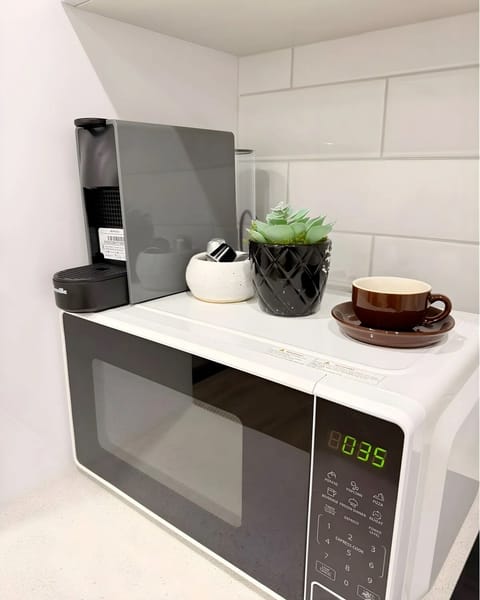 Kitchen with microwave, Nespresso machine, free coffee pods, plus complimentary sugar, milk, and tea