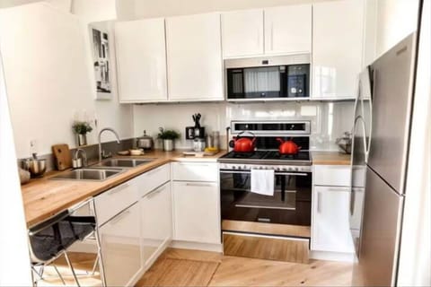 Large fully stocked kitchen with dishes, silverware, cooking ware.