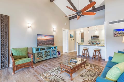 Stylish living space with tropical decor and turquoise accents, offering a cozy atmosphere and easy access to the kitchen for casual dining.