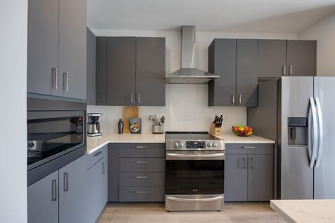 Unit 1: Fully equipped kitchen with brand-new stainless-steel appliances and a Kitchen island that offers ample counter space and bar seating.