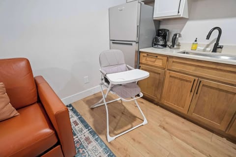 The kitchenette sits fully stocked for simple meals and morning coffee, with a high chair ready for little travelers. Warm wood cabinets and clean finishes keep the space bright and family friendly.