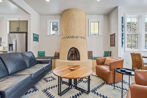 The adobe-style gas fireplace anchors the room with its curved lines and mosaic detailing, adding authentic Southwestern character. Surrounding seating makes it a perfect place to unwind after a day on the river or trails.