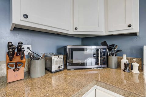 The kitchen comes stocked with everyday essentials including a toaster oven, microwave, and full knife set. Everything is within easy reach for simple meal prep.