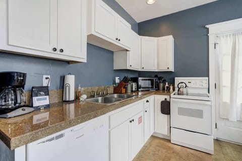 The kitchen includes a full appliance setup with cookware, a coffee maker, and plenty of cabinet space. It’s equipped with everything needed for simple meals or slow mornings at home.