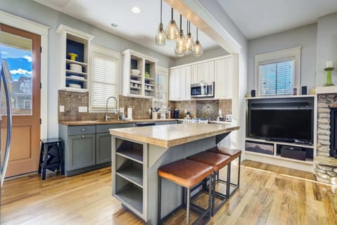 This view highlights the central island with seating, perfect for quick breakfasts or evening conversation while cooking. The open design keeps the kitchen connected to the living room, creating a comfortable hub for everyone to gather.