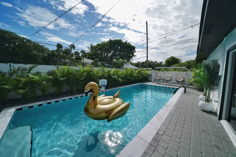 Relax and enjoy the backyard pool featuring in-water basketball, string lights overhead, and cozy hanging chairs for lounging in the back!