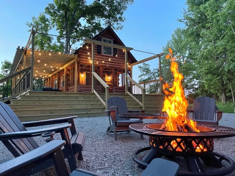 🔥 Gather around the crackling fire pit as the cabin lights twinkle above—your perfect log cabin evening begins right here. Share stories under the stars with the people you love. ✨🪑