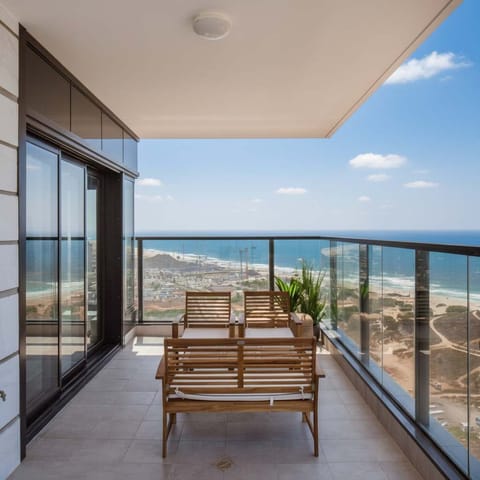 Expansive balcony seating invites relaxed mornings overlooking endless Mediterranean blues and glowing sunset skies above Bat Yam coastline.