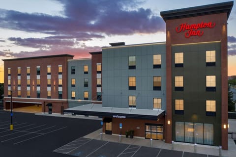 Hampton Inn building lit up at dusk with parking out front