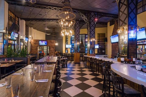 Bar and dining space with tall lights and plenty of seating