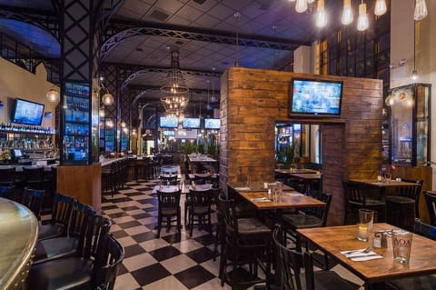 Dining area with warm lights, wood tables, and checkered floor