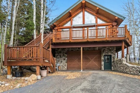 Beautiful mountain cabin surrounded by towering trees offers a perfect woodland retreat with stone details and spacious deck.