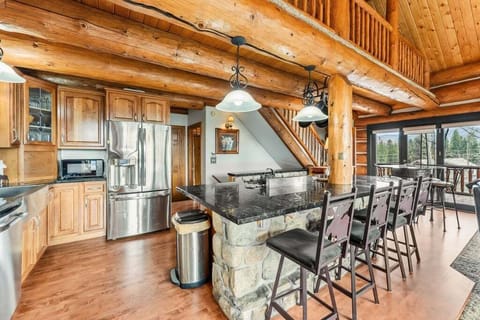Gather in this stunning open kitchen with stone countertops, warm wood beams, and mountain views from every angle.