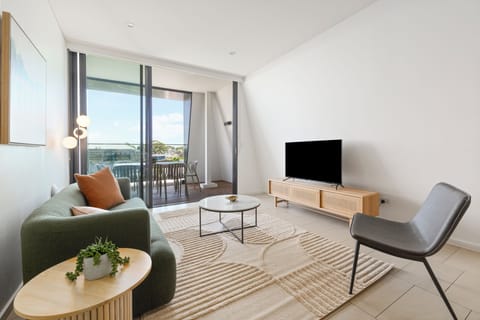 Unwind in a bright, open-plan living area where plush seating, soft artwork, and air-conditioned comfort create a relaxed retreat.