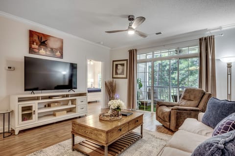 Open living room awaits with comfortable seating, modern entertainment center and sliding doors that open to your private balcony