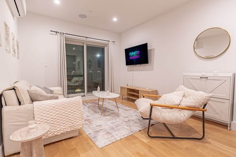 Boho-style living room with plush seating, smart TV and balcony access; relax in your Bushwick hidea