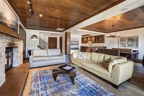 Elegant living room with vaulted ceilings, plush seating, and a stone fireplace — the heart of your mountain getaway.