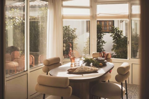 A sunlit dining nook framed by greenery—perfect for slow breakfasts and lively evening conversations.