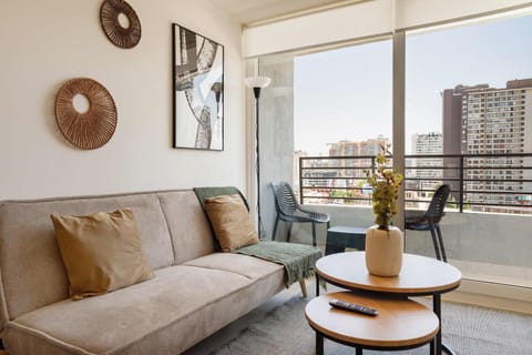 Private living room with a comfortable sectional, layered coffee tables, and floor-to-ceiling windows overlooking the city.
