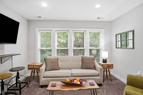 A bright and inviting upstairs living room with cozy seating, warm lighting, and a flat‑screen Roku TV. Enjoy “dinner and a show” at the floating bar, or unwind on the comfy sofa bed just steps from the full kitchen.