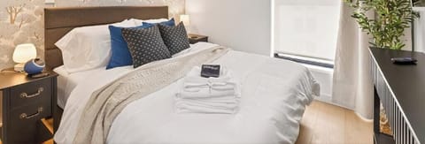 Queen bed, 10 foot ceilings, plush linens, blackout shades, and TV—designed for slow mornings and restful nights.