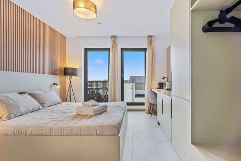 Inviting Living and Sleeping Space – Unwind in a cozy area featuring a queen-sized bed and a sophisticated wooden accent wall.