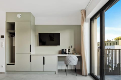 Functional Workspace and Entertainment Area – Wall-mounted TV, small desk, and a cozy chair create a perfect blend of comfort and productivity.