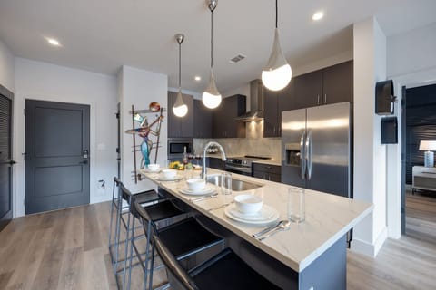 Unit 1: Fully equipped kitchen stocked with your basic cooking essentials. Includes stainless steel appliances, small kitchen island, coffee machine, and toaster.