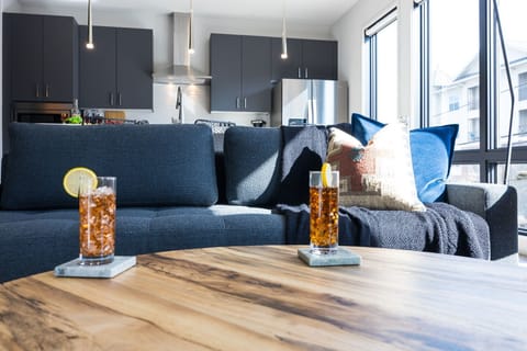 Unit 1: Bright open living space featuring a smart flat-screen TV, designer furnishings, and access to the private patio.