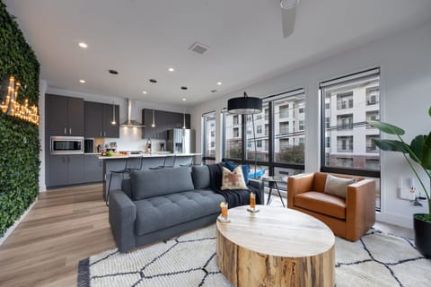 Unit 1: Bright open living space featuring a smart flat-screen TV, designer furnishings, and access to the private patio.