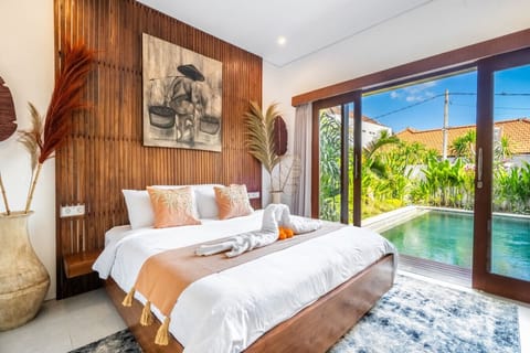 King bedroom with pool views and tropical decor