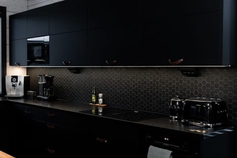 Modern kitchen with dark cabinets, combining elegance and functionality for a stylish cooking space.