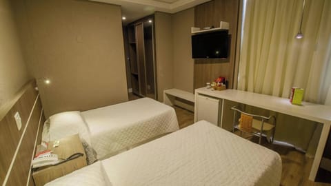 Recharge comfortably with twin beds, workspace, and soft lighting.