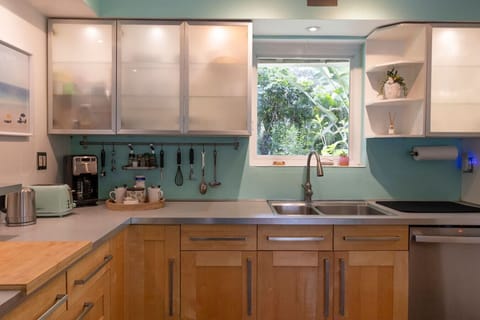 Modern fully equipped kitchen with stainless steel appliances, gas stove, and all cooking essentials.