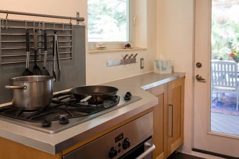 Modern fully equipped kitchen with stainless steel appliances, gas stove, and all cooking essentials.