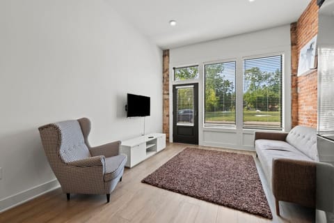 Unwind in our living room, featuring a cozy couch, a comfy chair, and a TV for entertainment.