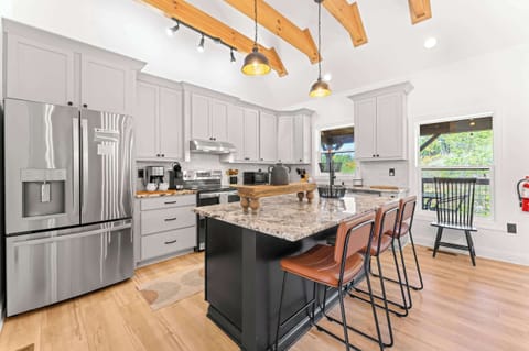 Fully equipped kitchen with stainless steel appliances, island seating for 3, and dining table for 6