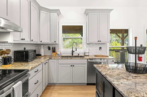 Fully equipped kitchen with stainless steel appliances, island seating for 3, and dining table for 6