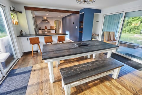 Dining table with 2 benches for seating. Sliding patio doors on both sides.