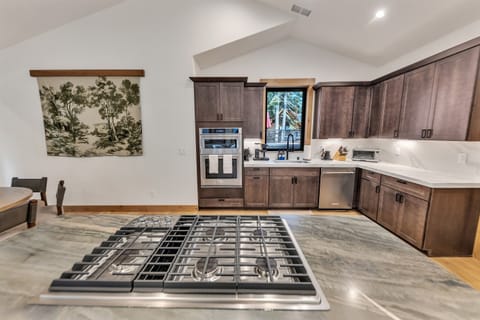 Kitchen with 5-burner gas range and with built in microwave/convection oven combo and full oven.