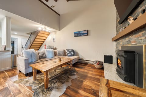 The living area features comfortable seating, a television, and a fireplace making it perfect for a cozy retreat.