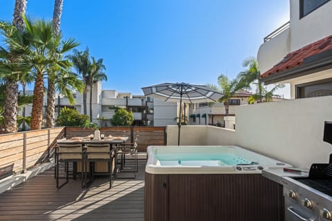 Outdoor patio with hot tub and dining area.