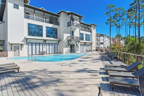 Resort-style community pool with ample lounge seating and a peaceful wooded backdrop.