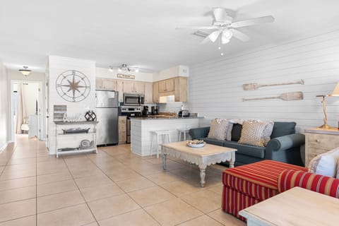 Living and kitchen area with coastal decor and modern appliances.