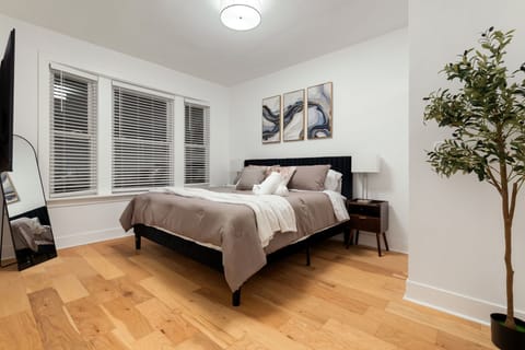 Calm bedroom retreat w/ a plush bed, soft light & uncluttered design.