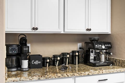 “Coffee lovers` corner featuring multiple machines, fresh beans, and all accessories for the perfect brew.”