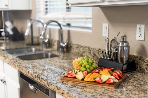 “Beautiful granite countertops highlighted with a fresh fruit display and sleek bar setup.”